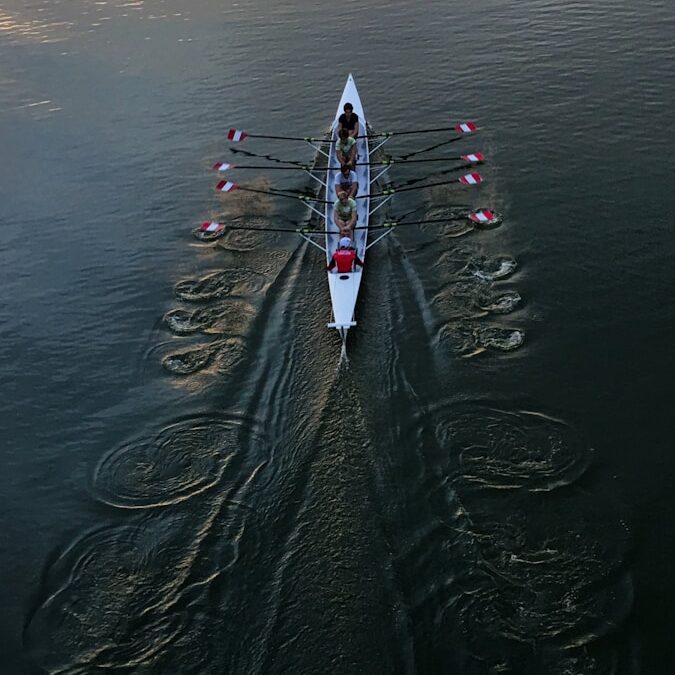 person in white shirt and black pants riding white surfboard on body of water during daytime