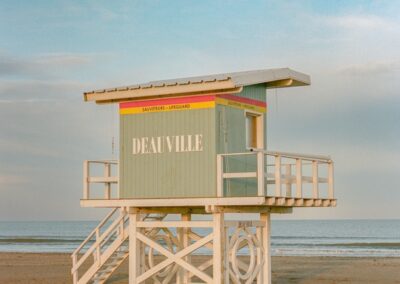 A pastel colored lifeguard station on a sandy beach.
