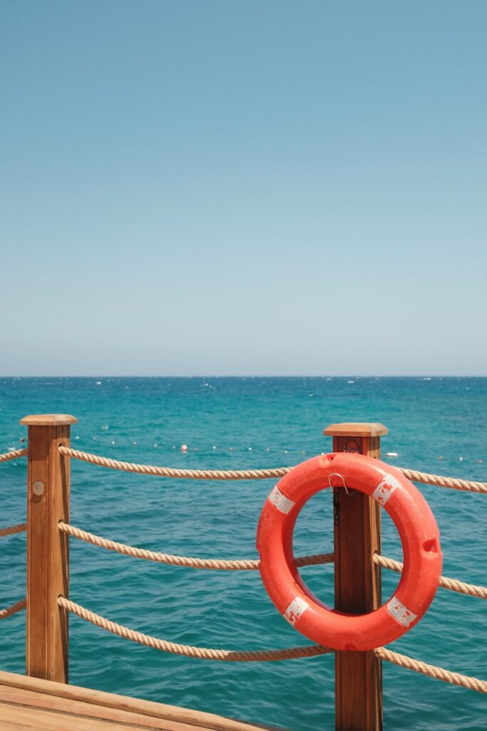 Orange life preserver on a wooden pier railing